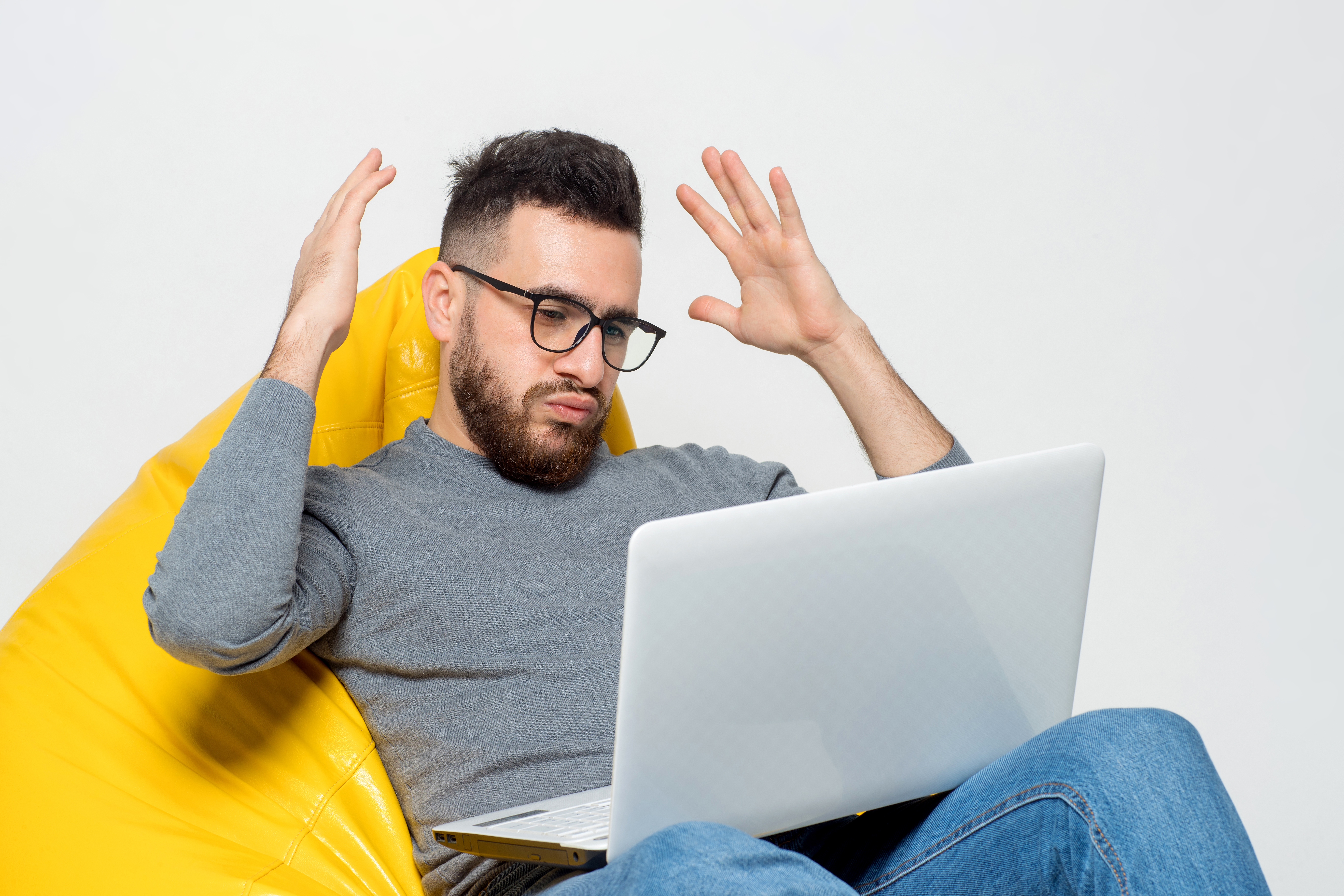 guy-suprised-while-sitting-on-yellow-pouf-chair